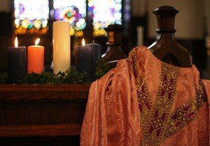 Wreath and Chasuble Advent wreath with newly lit rose candle beside rose-coloured chasuble